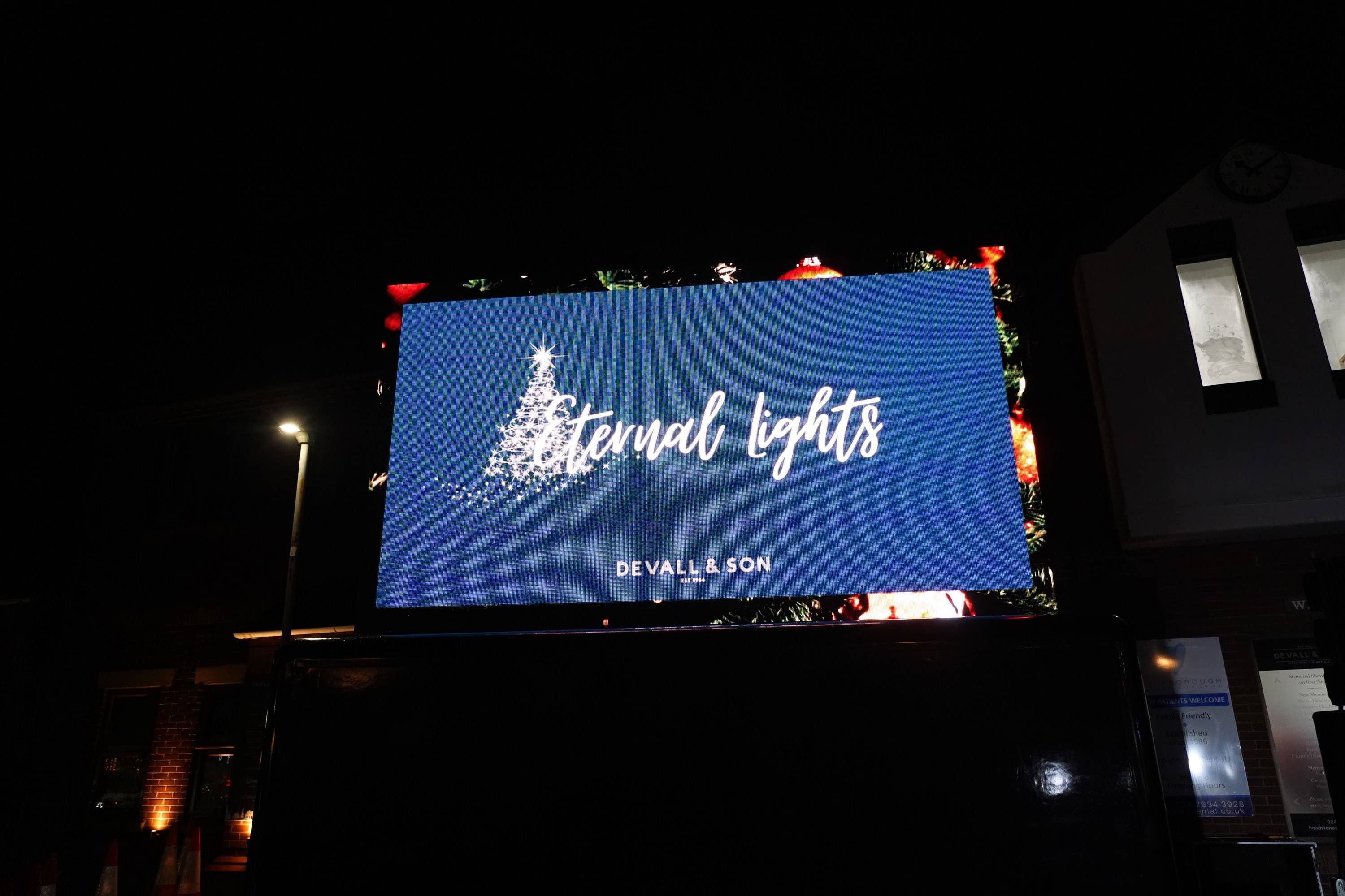 The big screen outside Devall & Son on Attleborough Green, showing the Eternal Lights title at last year's service